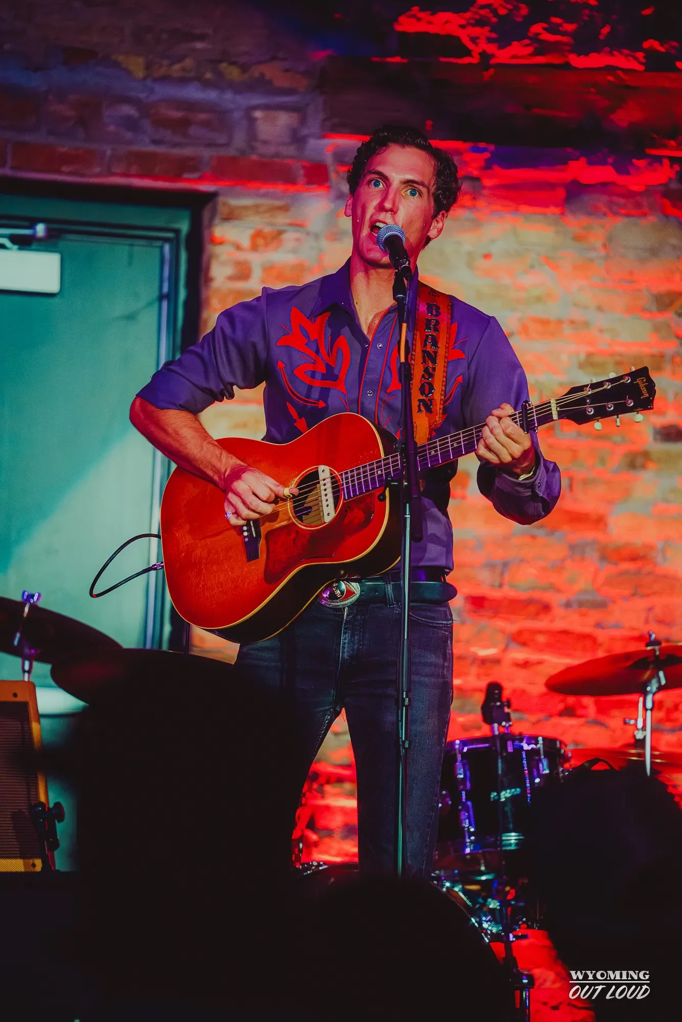 Musician performing against The Rialto brick wall