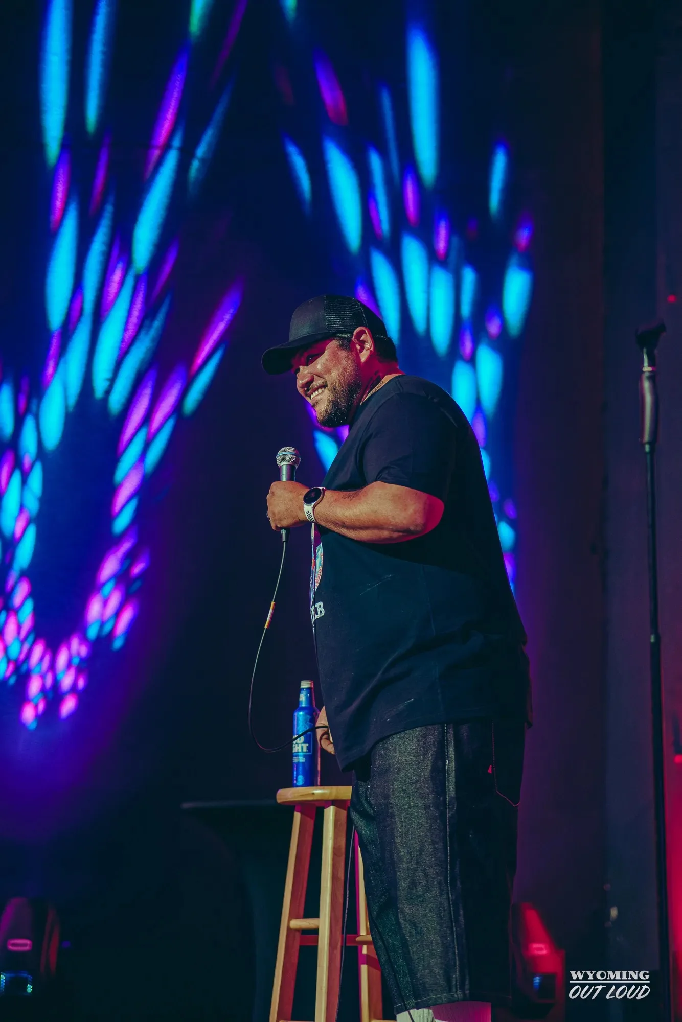 Comedian performing under colorful lights